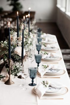 a long table with plates and candles on it