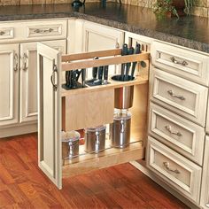 an open cabinet in a kitchen with pots and pans on the bottom shelf,