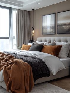 a large bed sitting in a bedroom next to a window covered in blankets and pillows