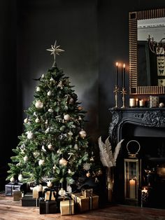 a decorated christmas tree in front of a fireplace