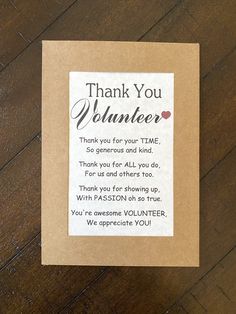 a thank you volunteer card sitting on top of a wooden table