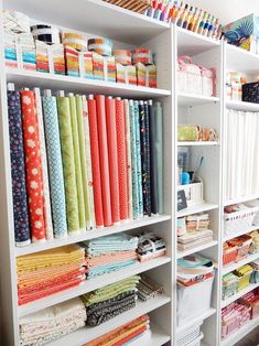 the shelves are filled with many different fabrics