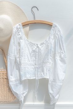 A staple of the coquette wardrobe, this button-up blouse in lace-accented semi-sheer white cotton features a button-up front, cropped peplum hem, and full sleeves with bow-accent cuffs. Wear with a midi skirt or with your favorite jeans for a no-effort French chic look! Please Note- This item is final sale only. . Details: S: Bust 33", Length 18" M: Bust 35", Length 18.5" L: Bust 37", Length 19" Length Measured from Shoulder Unlined, Semi-Sheer Material: 100% Cotton Imported Hand Wash Cold / Lin Coquette Wardrobe, White Blouse Top, French Girl Style, French Chic, Peplum Hem, Sheer Material, Cotton Blouse, French Girl, Full Sleeves