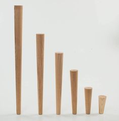 four wooden poles are lined up against a white background and one is in the foreground