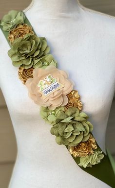 a white mannequin with green and gold flowers on it