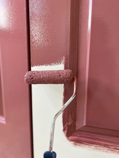 a pink painted door with a paint roller