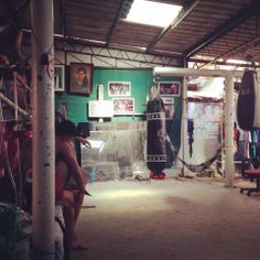 a man sitting on a bench in a room filled with boxing gloves and punching pads