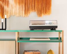 an old record player is sitting on a shelf next to some books and a vase