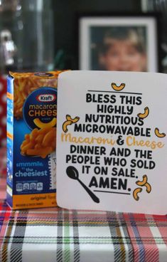 a box of macaroni and cheese sitting on top of a plaid table cloth