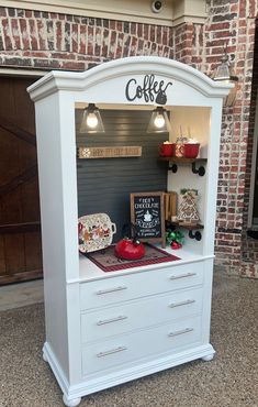 a white cabinet with drawers and lights on it's sides in front of a brick building