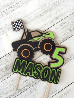 a monster truck cake topper with the number five on it