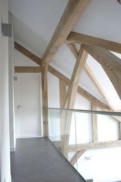 an empty room with wooden beams and glass railing