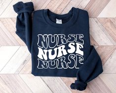 a sweatshirt with the words nurse and nurse's nurse on it sitting on a wooden floor