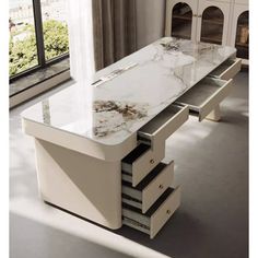 a marble top desk with drawers in front of a window