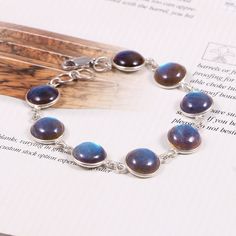 This Sterling Silver Bracelet features an Elegant Art With Natural Labradorite Gemstone. The cavity is made from genuine solid 925 sterling silver and stamped as S925. This Jewelry is Lead free. ITEM DESCRIPTION Item Code: JABR58 Metal: 925/92.5 Sterling Silver Gemstone: Genuine Natural Labradorite Cabochon (Handcrafted) Gemstone Shape: Round Gemstone Size: 10 MM **Keep the jewelry away from direct heat, water, perfumes, deodorants, and other strong chemicals. Wipe the Jewellery gently with a ch Rings Vintage Boho, Red Ruby Earrings, Meditation Bracelet, Labradorite Bracelet, Energy Bracelets, Round Art, Silver Chain Style, Labradorite Cabochon, Ruby Earrings