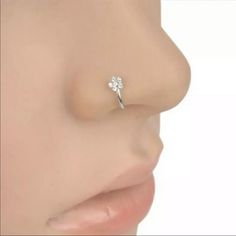 a woman's nose with a single diamond ring on it