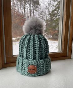 "Keep warm in this chunky hand crocheted fold over hat Button inside to remove Pompom  20% wool 80% acrylic Height: 8.5\" (measurement does not include Pompom) Circumference: 20\" Hand wash hat only  Lay flat to dry  *Color may look slightly different depending on viewing screen" Cozy Green Hat For Fall, Cozy Green Fall Hats, Green Yarn Crochet Hat For Outdoor, Handmade Green Crochet Hat For Winter, Green Crochet Hat For Winter, Green Fitted Crochet Hat For Winter, Winter Green Crochet Hat, Sarah Nicole, Handmade Gifts For Friends