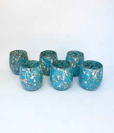 five blue vases sitting next to each other on a white surface