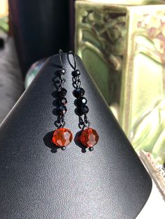 "These simple but elegant earrings were made to match the Black Red Orange Multi Strand Art Deco Style Necklace w/ Heart Pendant Pendant and Bracelet. Made with jet black 4mm round crystals and 8mm round faceted round crystals. Black coated brass ear hooks. Length: 1 7/8\" Matching pieces available: Heart Pendant Necklace: https://www.etsy.com/listing/896700815/black-red-orange-multi-strand-art-deco Bracelet https://www.etsy.com/listing/898954585/black-red-orange-multi-art-deco-style" Handmade Black Clip-on Earrings For Gift, Handmade Black Dangle Clip-on Earrings, Handmade Gothic Drop Earrings, Gothic Handmade Drop Earrings, Black Hypoallergenic Earrings For Party, Gothic Adjustable Earrings With Ear Wire, Black Beaded Earrings With Ear Wire For Gift, Adjustable Gothic Earrings With Ear Wire, Gothic Handmade Earrings For Party