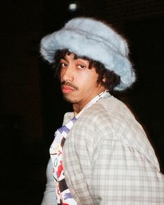 a man wearing a hat and tie with a fake fur on it's head