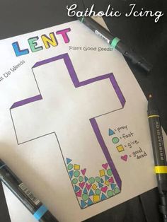 a cross is shown on top of a paper with crayons next to it