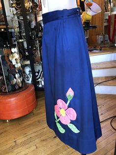 Hand Crafted Wrap Around Skirt, Royal Blue Cotton Skirt with pink Floral Appliqué and Embroidery front and back. Women's medium. Could extend to large. In good used condition! Traditional Wrap Skirt For Spring, Fitted Blue Skirt With Floral Embroidery, Traditional Blue Lined Skirt, Long Blue Embroidered Skirt, Blue Embroidered Long Skirt, Blue Cotton Skirt, Prom Purse, Leisure Suit, Beaded Evening Bags