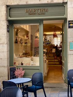 the outside of a restaurant with tables and chairs