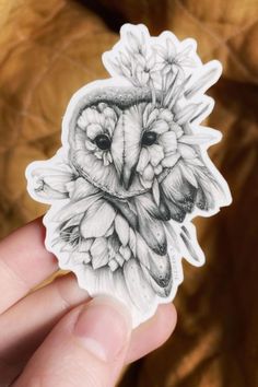 an owl sticker in the palm of someone's hand