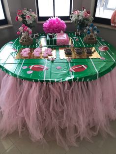 a table topped with cake and cupcakes on top of a green table cloth