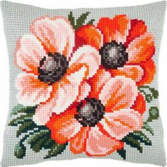 a cross stitched pillow with an orange and white flower design on the front side