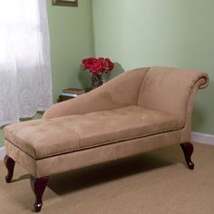 a tan chaise lounger sitting on top of a carpeted floor next to a window