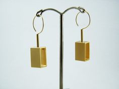 "Geometric gold statement earrings, Movement jewelry, Gold Rectangle dangle earrings, Kinetic earrings. Sophisticated Geometric statement earrings. SGolden rectangles earrings part of my new\"kinetic jewelry \"collection that influenced by geometric architecture and mainly Inspired by Kinetic Art - \"Kinetic art is art from any medium that contains movement perceivable by the viewer or depends on motion for its effect.\" These earrings consists golden rectangles + goldfilled tube connected to a Kinetic Earrings, Kinetic Jewelry, Geometric Statement Earrings, Geometric Architecture, Kinetic Art, Rectangle Earrings, Gold Statement Earrings, Jewelry Gold, Candle Sconces