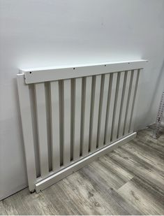 a white radiator sitting on top of a wooden floor next to a wall