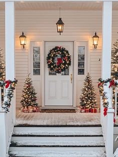 the front porch is decorated for christmas with wreaths and lights