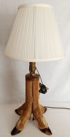 a lamp that is on top of a wooden base with fake animal feet underneath it