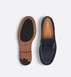 Debuting with the Fall 2024 Collection, the Dior Granville loafer presents a refined version of an urban shoe. Made in deep blue grained calfskin with contrasting topstitching, the style is embellished with a tonal Saddle strap on the vamp. The creation is completed by a leather sole and an engraved Dior signature on the back. The shoe can be worn with any seasonal attire for an elegant and timeless look.. 45 Navy Loafers With Leather Sole For Work, Formal Calf Leather Moccasins With Contrast Sole, Navy Leather Loafers With Leather Sole, Classic Navy Loafers With Leather Sole, Blue Calf Leather Loafers With Rubber Sole, Classic Blue Moccasins With Brogue Detailing, Classic Blue Leather Loafers, Navy Leather Business Loafers, Navy Leather Formal Loafers