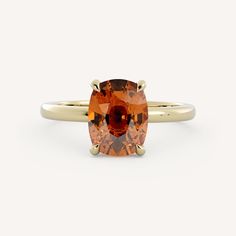 an orange topazte ring set in yellow gold, with a large oval cut