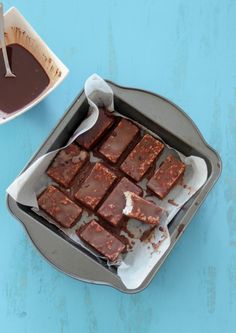 a pan filled with brownies sitting on top of a blue table