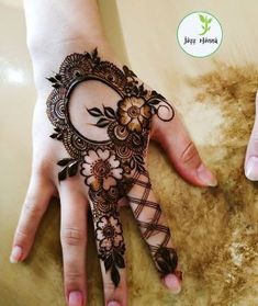 a woman's hand with henna on it and flowers painted on the palm