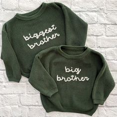 two green sweaters with the words biggest brother and big brother written on them against a white brick wall