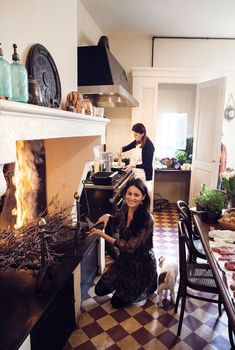 a woman is sitting in front of an oven on the cover of a home magazine