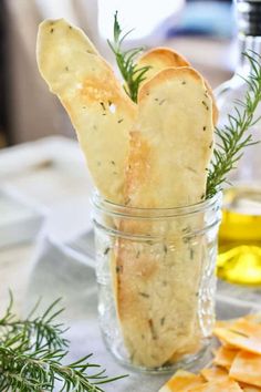 some bread sticks are in a glass jar