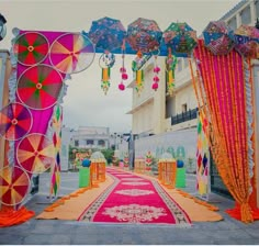 an outdoor ceremony decorated with colorful umbrellas and draping on the side walk