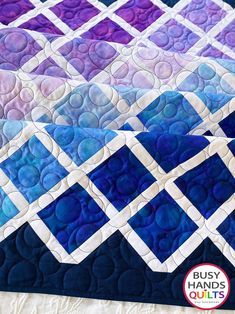 the quilt is made with blue and purple squares