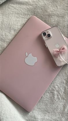 an iphone case with a pink bow on the front and back, sitting on a bed