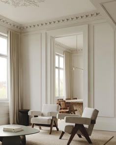 a living room filled with white furniture and large windows next to a window covered in curtains