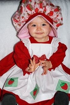 a baby dressed in a red and white dress