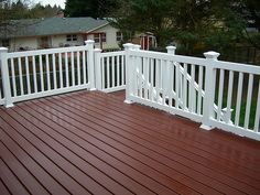 a wooden deck with white railings and rails