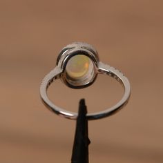 It is a natural opal ring. The main stone is 7mm*9mm oval white opal. The basic metal is sterling silver and plated with rhodium. To change the metal to a solid gold (white/rose) or platinum is also available, please ask for a quotation if you want. You can also go to my shop Home for more elegant rings: https://www.etsy.com/shop/godjewelry?ref=hdr_shop_menu Opal is the birthstone of October, it will be a great gift for your lover! Customization is always welcome and please feel free to contact Fine Jewelry Oval Opal Ring With Polished Finish, Oval Opal Ring With Polished Finish In Fine Jewelry, Oval Opal Ring With Polished Finish, Oval Opal Rings With Polished Finish, Opal Oval Cabochon Ring With Polished Finish, Polished Opal Ring In Oval Cabochon Shape, Polished Opal Oval Cabochon Ring, Polished Opal Ring For Anniversary, Oval Opal Rings With Bezel Setting