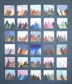 a quilted wall hanging with many different mountains on it's sides and squares in the middle